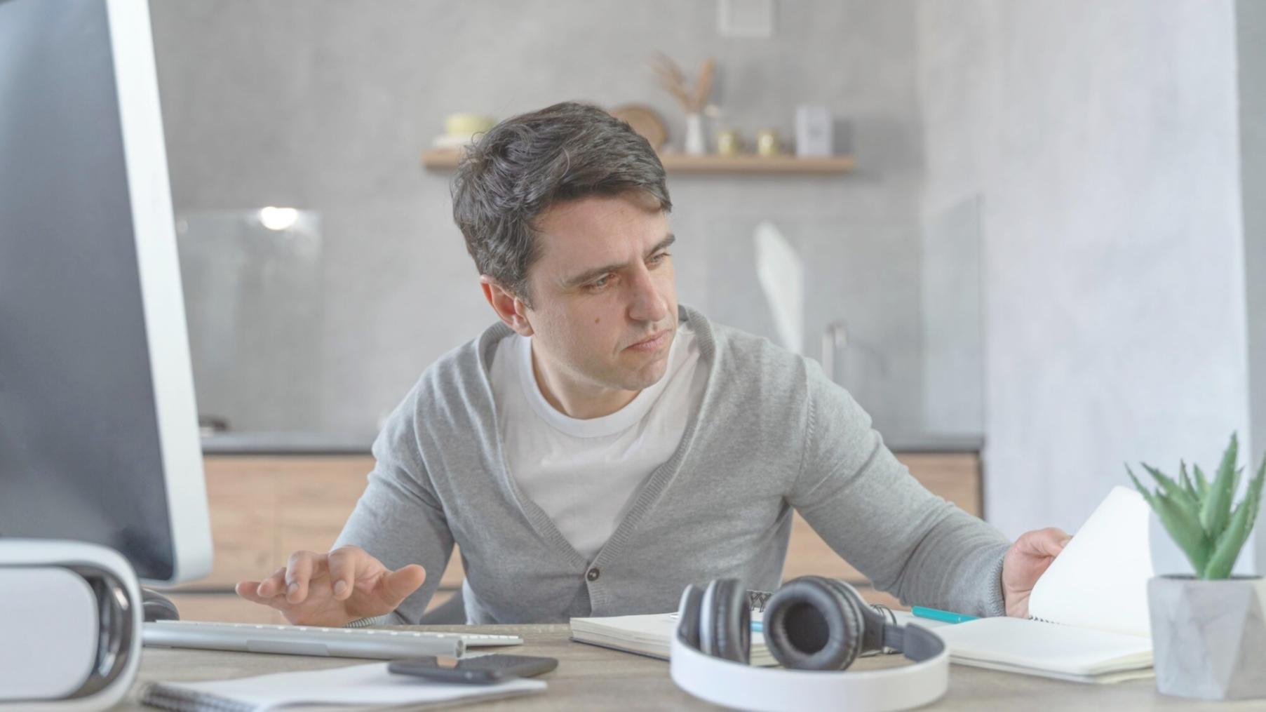 Family discussing budget plans around kitchen table with notebooks and laptop
